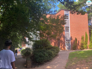 A teenage boy walks along a college campus