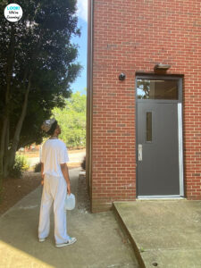 A teenage boy looks up at a college dormitory