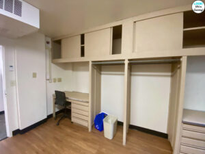 The shared desks and storage cabinets in a freshman college dormitory bedroom